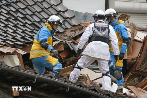 Lực lượng cứu hộ tìm kiếm nạn nhân mắc kẹt trong đống đổ nát sau trận động đất tại tỉnh Ishikawa. (Ảnh: Kyodo/TTXVN)