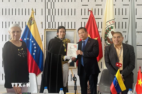 Tiến sỹ Juan Gamez trao tặng ảnh Chủ tịch Hồ Chí Minh do chính ông vẽ cho Đại sứ Việt Nam tại Venezuela Vũ Trung Mỹ. (Ảnh: TTXVN phát)
