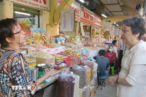 Lãnh đạo Sở An toàn thực phẩm Thành phố Hồ Chí Minh trao đổi với tiểu thương chợ Bình Tây về công tác đảm bảo an toàn thực phẩm. (Ảnh: Đinh Hằng/TTXVN)