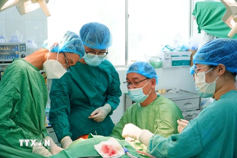 Các bác sỹ Bệnh viện Chợ Rẫy tiến hành nối vi phẫu toàn bộ da đầu bị lóc của bệnh nhân. (Ảnh: TTXVN phát)