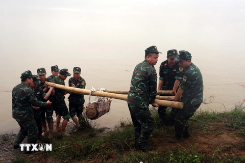 Lực lượng công binh tỉnh Hưng Yên di dời quả bom về nơi hủy nổ. (Ảnh: Đinh Văn Nhiều/TTXVN)