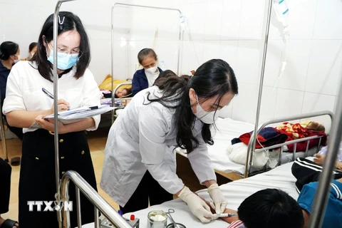 Cán bộ Trung tâm Kiểm soát bệnh tật lấy mẫu máu xét nghiệm. (Ảnh: Công Tường/TTXVN)