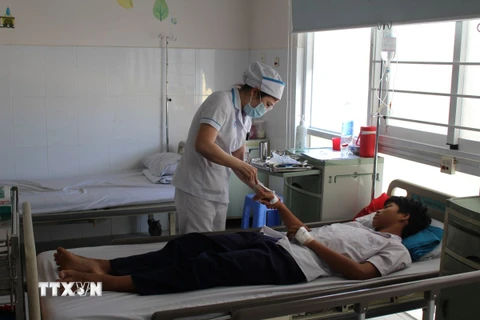 Bác sỹ Bệnh viện Đa khoa Tâm Trí Nha Trang chăm sóc sức khỏe cho bệnh nhân nghi ngộ độc thực phẩm sau khi ăn sáng 5/4. (Ảnh: Phan Sáu/TTXVN)