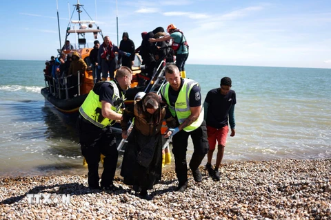 Lực lượng chức năng Anh hỗ trợ người di cư được giải cứu khi đang cố vượt eo biển Manche từ Pháp vào Anh, ngày 16/8/2023. (Ảnh: AFP/TTXVN)