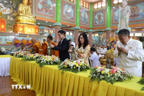 Thứ trưởng Ngoại giao Lê Thị Thu Hằng, Đại sứ Phạm Việt Hùng cùng các vị sư và Phật tử thực hiện nghi thức tắm tượng. (Ảnh: Đỗ Sinh/TTXVN)