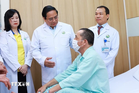 Thủ tướng Phạm Minh Chính thăm bệnh nhân được ghép gan từ người cho gan chết não. (Ảnh: Dương Giang/TTXVN)