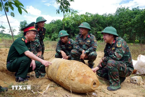 Lực lượng chức năng khảo sát, lên phương án hủy nổ quả bom. (Ảnh: TTXVN phát)