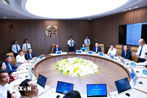 Thủ tướng Phạm Minh Chính tham quan hệ thống phòng họp thông minh của thành phố Hà Nội. (Ảnh: Dương Giang/TTXVN)