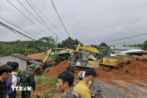 Lực lượng chức năng cùng thiết bị cơ giới triển khai công tác cứu hộ, giải tỏa hiện trường. (Ảnh: TTXVN phát)