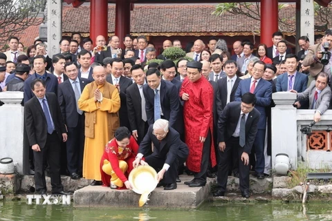 Tổng Bí thư, Chủ tịch nước Nguyễn Phú Trọng và Phu nhân cùng kiều bào tham dự Chương trình Xuân Quê hương năm 2019 thực hiện nghi thức thả cá chép theo phong tục truyền thống tại hồ Hoàn Kiếm, Hà Nội. (Ảnh: Trí Dũng/TTXVN)