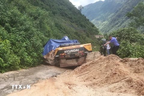 Lực lượng chức năng có mặt tại hiện trường để chỉ đạo công tác khắc phục vụ sạt lở. (Ảnh: TTXVN phát)