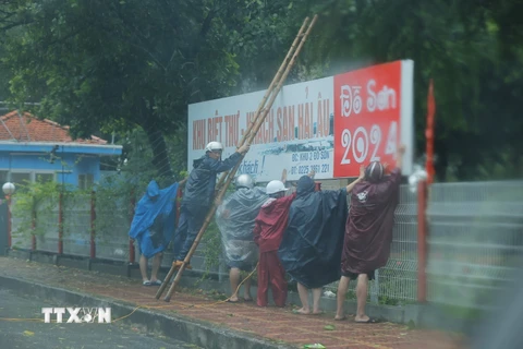 Người dân chằng chống nhà khi bão đang vào đất liền (ảnh chụp lúc 9 giờ). (Ảnh: Minh Quyết/TTXVN)