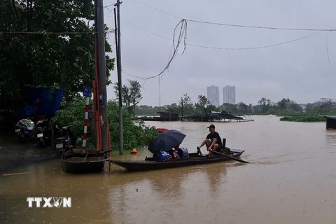 Học sinh sinh sống ở khu vực ven sông Hồng thuộc phường Chương Dương (Hoàn Kiếm) phải đi học bằng thuyền. (Ảnh: TTXVN phát)