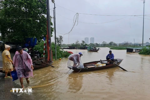 Nước sông Hồng dâng cao, ảnh hưởng đến đời sống sinh hoạt, di chuyển của người dân. (Ảnh: TTXVN phát)