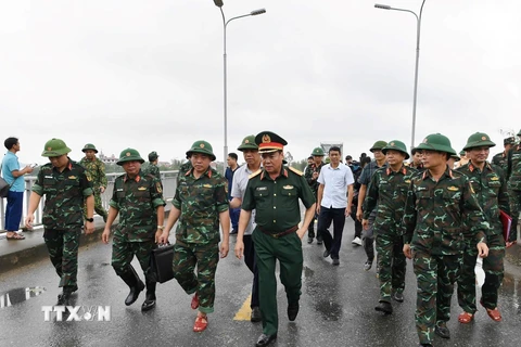 Trung tướng Phạm Đức Duyên, Bí thư Đảng ủy, Chính ủy Quân khu 2 và đại diện các đơn vị khảo sát vị trí lắp cầu phao. (Ảnh: TTXVN phát)