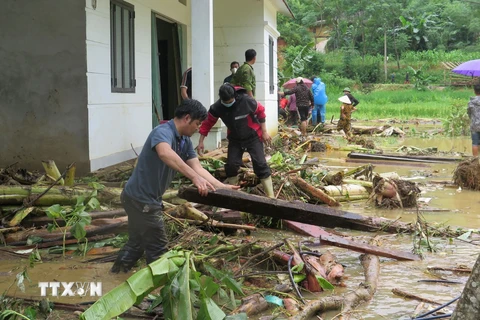 Người dân địa phương nỗ lực tìm người thân bị nạn sau lũ dữ. (Ảnh: Hồng Ninh/TTXVN)