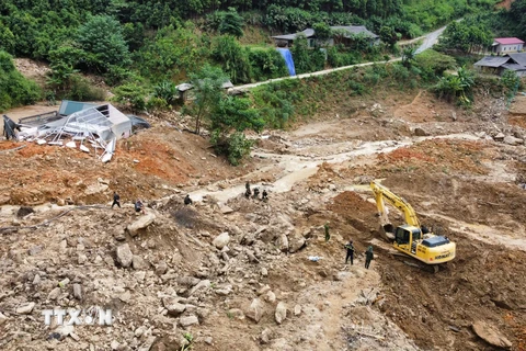 Lực lượng công an, quân đội cùng máy móc cơ giới nỗ lực, khẩn trương tìm kiếm các nạn nhân đang mất tích. (Ảnh: Hoàng Hiếu/TTXVN)