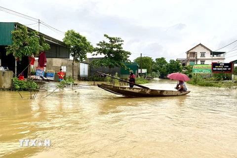 Người dân xã Kim Hoa, huyện Hương Sơn sử dụng thuyền để di chuyển trong vùng ngập nước. (Ảnh: Hữu Quyết/TTXVN)