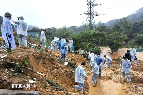 Cán bộ, chiến sỹ Công an tỉnh Hà Giang và các lực lượng chức năng nỗ lực tìm kiếm nạn nhân mất tích trong vụ sạt lở nghiêm trọng. (Ảnh: TTXVN phát)