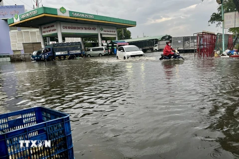 Ngập úng sâu ở cây xăng trên đường Nguyễn Văn Linh, Quận 8. (Ảnh: Thanh Vũ/TTXVN)