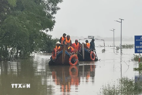 Các lực lượng chức năng di chuyển bằng thuyền hỗ trợ người dân vùng ngập lụt. (Ảnh: Thanh Thủy/TTXVN)