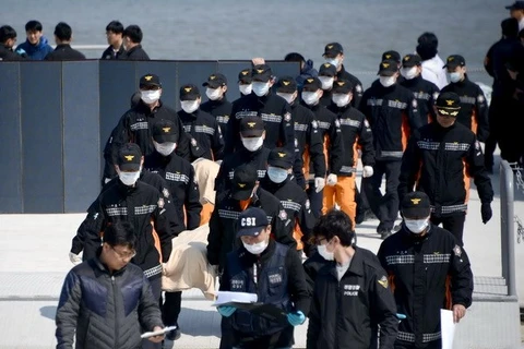Lực lượng cứu hộ chuyển xác nạn nhân lên cảng Jindo ngày 20/4. (Nguồn: AFP/TTXVN)