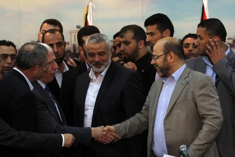 Trưởng đoàn đàm phán của Fatah Azzam al-Ahmed (giữa, trái) và Phó lãnh đạo Phong trào Hamas Musa Abu Marzuk (phải) sau lễ ký thỏa thuận hòa giải tại Gaza ngày 23/4. (Ảnh: AFP/TTXVN)