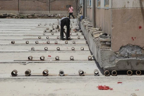 Các công nhân Trung Quốc dùng những con lăn để di dời bệnh viện