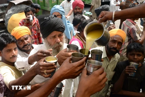 Tình nguyện viên phát nước hoa quả miễn phí cho người đi đường nhằm giải nhiệt khi nắng nóng hoành hành tại Amritsar ngày 29/5. (Nguồn: AFP/TTXVN)