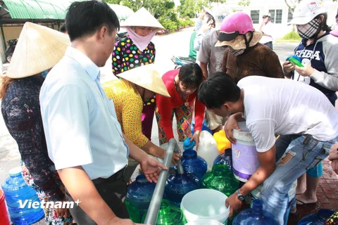 Người dân dùng tất cả các vật dụng có thể sử dụng được để lấy nước ở các xe bồn. (Nguồn: Bùi Trường Giang/Vietnam+)