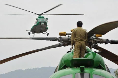 Một binh sỹ Lào theo dõi máy bay Mi-17 hạ cánh. (Nguồn: AFP)