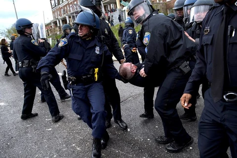 Cảnh sát chuyển một sỹ quan cảnh sát bị thương do người biểu tình tấn công. (Nguồn: AFP) 