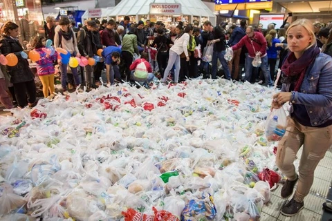 Người dân Đức chuẩn bị hàng trăm túi thực phẩm chờ chuyến tàu đặc biệt chở hàng trăm người di cư tới Frankfurt am Main, miền tây nước Đức ngày 5/9. (Nguồn: AFP/TTXVN)