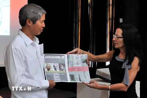 Tổng thư ký OSPAAL Lourdes Cervantes Vasquez (phải) trao tặng một poster về quan hệ song phương cho Đại sứ Việt Nam Dương Minh. (Ảnh: Lê Hà/TTXVN)