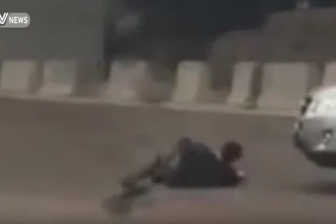 Người đàn ông giả vờ ngã trước xe ôtô. (Nguồn: CCTV)