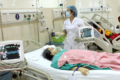 Nhân viên y tế chăm sóc cho bệnh nhân những ngày Tết. (Ảnh: TTXVN)