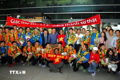 Người hâm mộ chào đón và tặng hoa cho đội tuyển futsal Việt Nam. (Ảnh: Mạnh Linh/TTXVN)