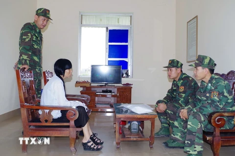 Lực lượng chức năng lấy lời khai Đối tượng Vũ Thị Liên. (Ảnh: Nguyễn Hoàng/TTXVN) 