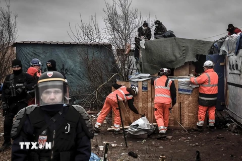 Pháp dỡ bỏ một phần khu lán trại trái phép của những người di cư được dựng lên ở thành phố cảng Calais. (Nguồn: AFP/TTXVN)