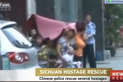 Hai kẻ bắt cóc chùm chăn lên đầu con tin. (Nguồn: CCTV)