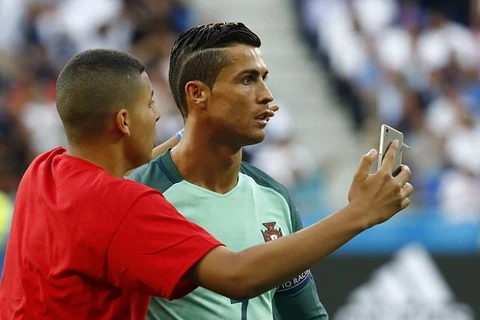 Cậu bé chạy đến bên Ronaldo để chụp ảnh cùng thần tượng của mình