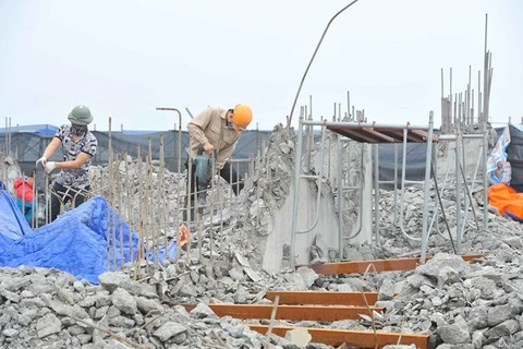 Công nhân tiến hành khoan, phá dỡ phần công trình xây dựng trái phép ở toà nhà số 8B Lê Trưc, Hà Nội, sáng 6/3. (Ảnh: Minh Đức/TTXVN)