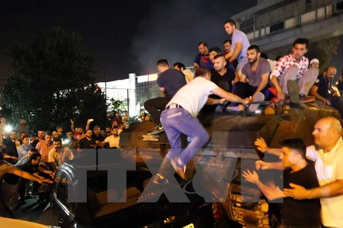 Người dân ủng hộ Tổng thống Thổ Nhĩ Kỳ Recep Tayyip Erdogan nỗ lực ngăn chặn xe tăng do lực lượng đảo chính triển khai trên đường phố Istanbul ngày 16/7. (Nguồn: EPA/TTXVN) 