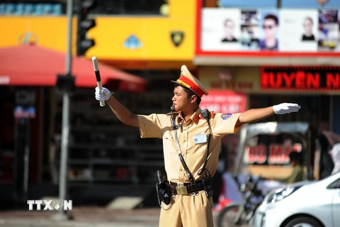 Lực lượng cảnh sát giao thông vẫn phải duy trì công việc tại những nút giao thông trọng yếu. (Ảnh: Quang Quyết/TTXVN)