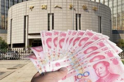 Đồng tiền giấy mệnh giá 100 nhân dân tệ được giới thiệu bên ngoài Ngân hàng PBOC tại Bắc Kinh. (Ảnh: Kyodo/TTXVN)
