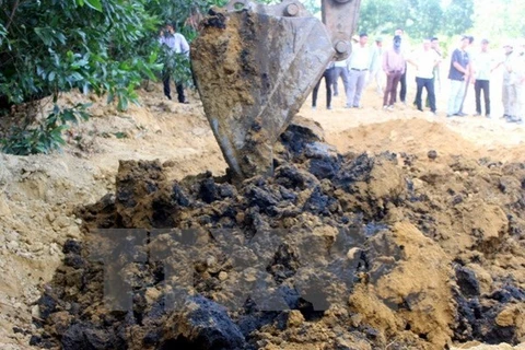 Lực lượng chức năng dùng máy xúc để đào chất thải của Công ty Formosa Hà Tĩnh chôn lấp tại trang trại ông Lê Quang Hòa, tại phường Kỳ Trinh, thị xã Kỳ Anh. (Ảnh: Phan Quân/TTXVN)