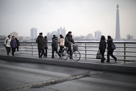 Người dân Triều Tiên đi trên một cây cầu bắc qua sông Taedong. (Nguồn: Sputniknews)