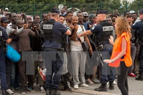 Cảnh sát giám sát, phân loại những người tị nạn tại Calais. (Nguồn: AFP/TTXVN)