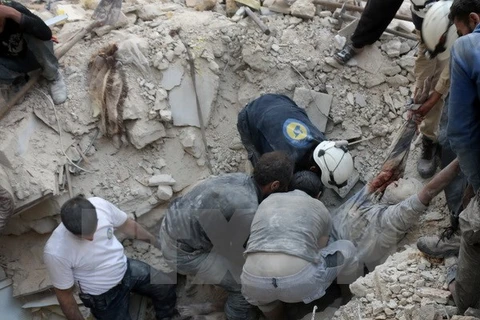 Tình nguyện viên Syria chuyển thi thể một nạn nhân sau một vụ không kích tại Aleppo ngày 4/10. (Nguồn: AFP/TTXVN)