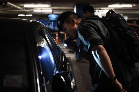 Cảnh sát kiểm tra chiếc xe ôtô ra vào một trung tâm thương mại ở Bangkok. (Nguồn: AFP)